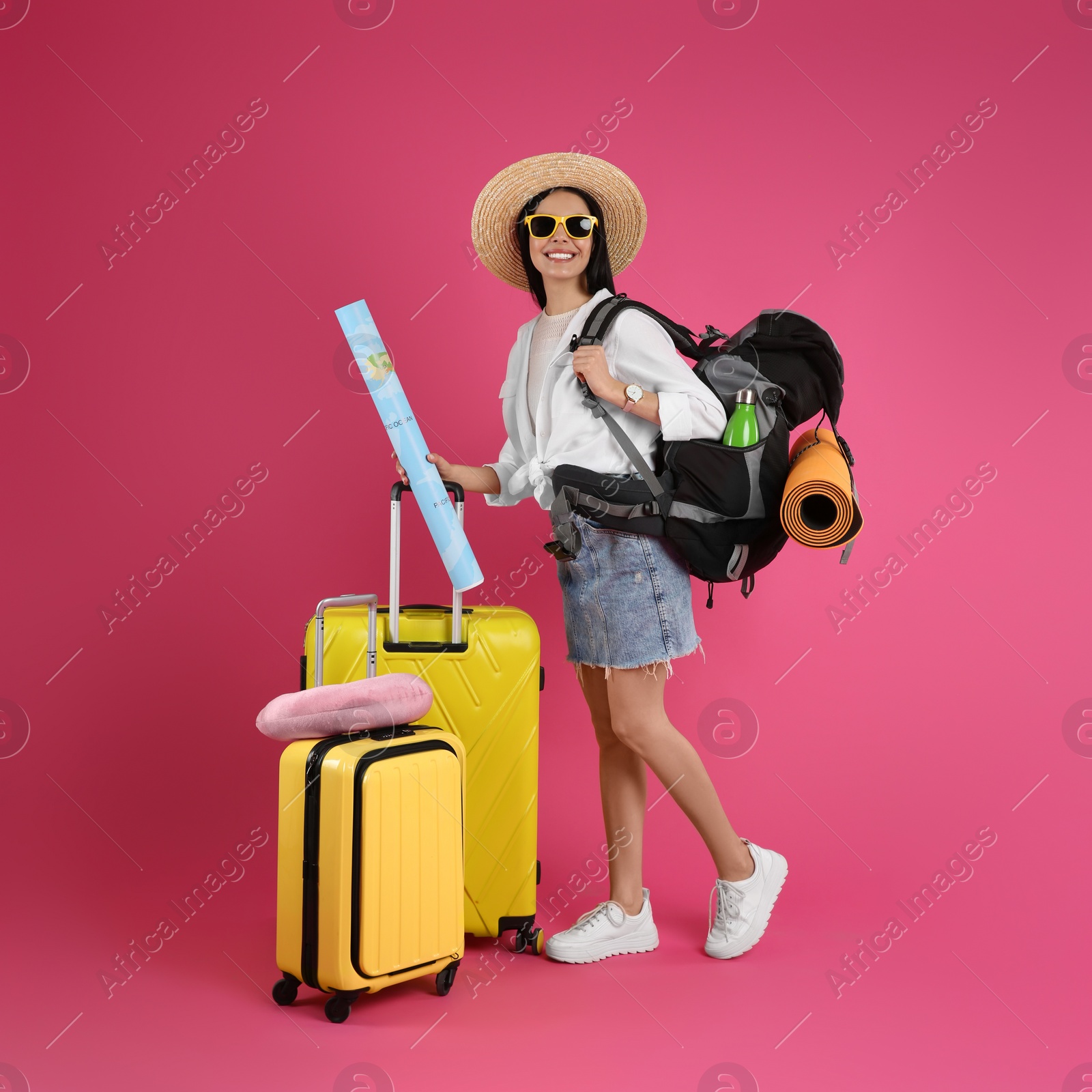 Photo of Female tourist with travel accessories on pink background