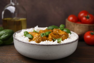 Photo of Delicious rice and chicken with curry sauce served on wooden table, closeup