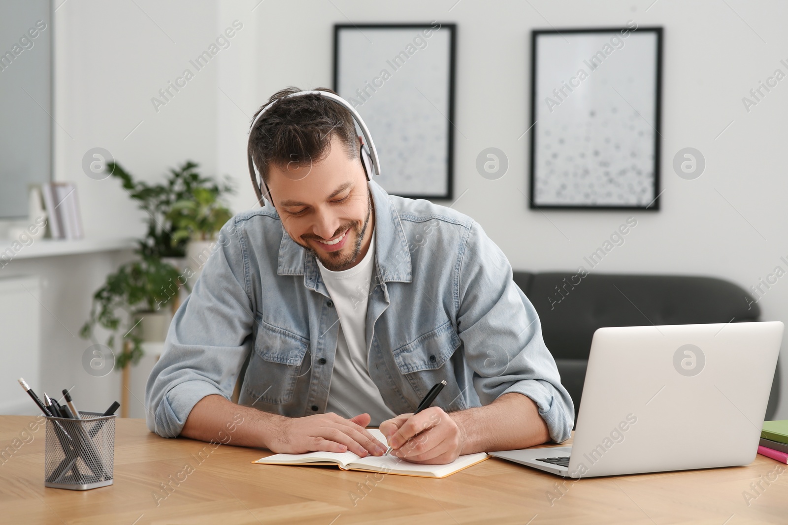 Photo of Online translation course. Man writing near laptop at home
