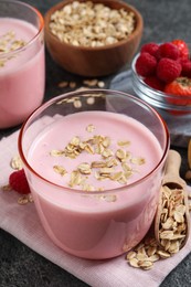 Glass of tasty berry smoothie with oatmeal on grey table, closeup
