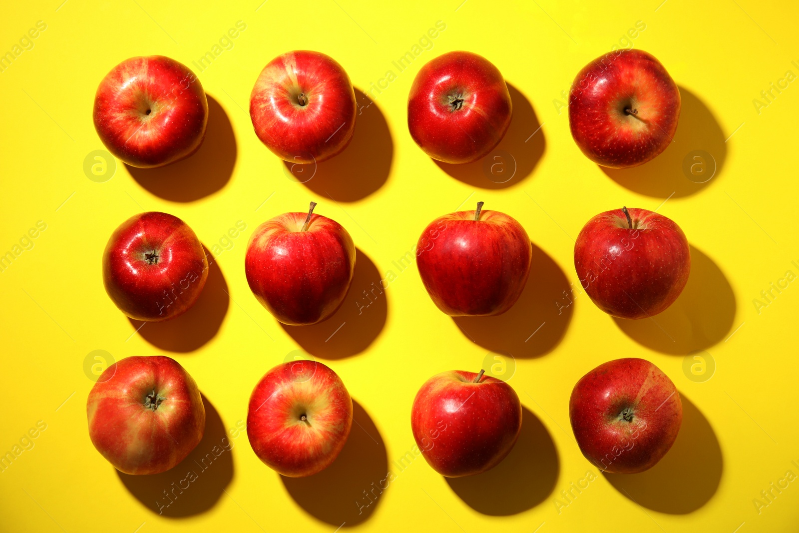 Photo of Fresh ripe red apples on yellow background, flat lay