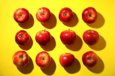 Fresh ripe red apples on yellow background, flat lay