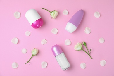 Photo of Flat lay composition with different female roll-on deodorants on pink background