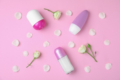 Flat lay composition with different female roll-on deodorants on pink background