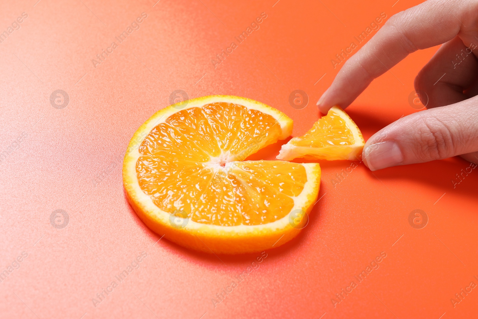 Photo of Woman with slices of juicy orange on terracotta background, closeup