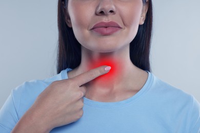 Image of Endocrine system. Woman doing thyroid self examination on grey background, closeup