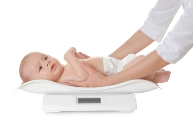 Doctor weighting baby on scales against white background