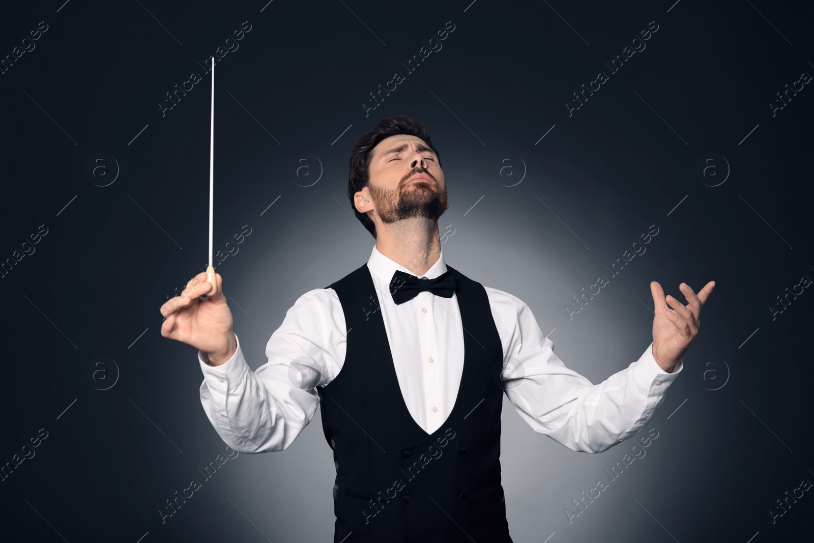 Photo of Professional conductor with baton on dark background