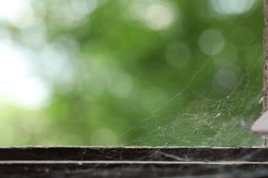 Photo of Cobweb on old wooden window frame indoors, closeup