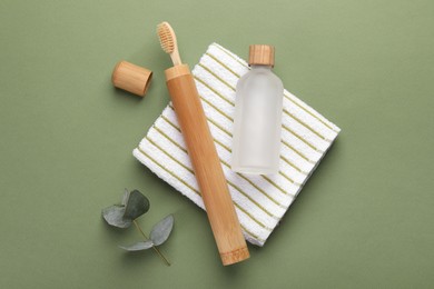 Photo of Flat lay composition with bamboo toothbrush on green background