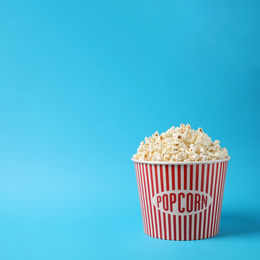 Photo of Delicious popcorn on light blue background. Space for text