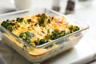 Photo of Tasty broccoli casserole in baking dish on table, closeup