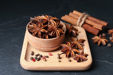 Photo of Aromatic anise stars and spices on black table