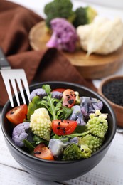 Photo of Delicious salad with cauliflower and tomato served on white wooden table