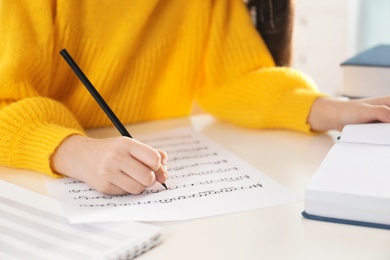Photo of Child writing music notes at table, closeup