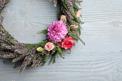 Photo of Beautiful autumnal wreath with heather flowers on light grey wooden background, top view. Space for text