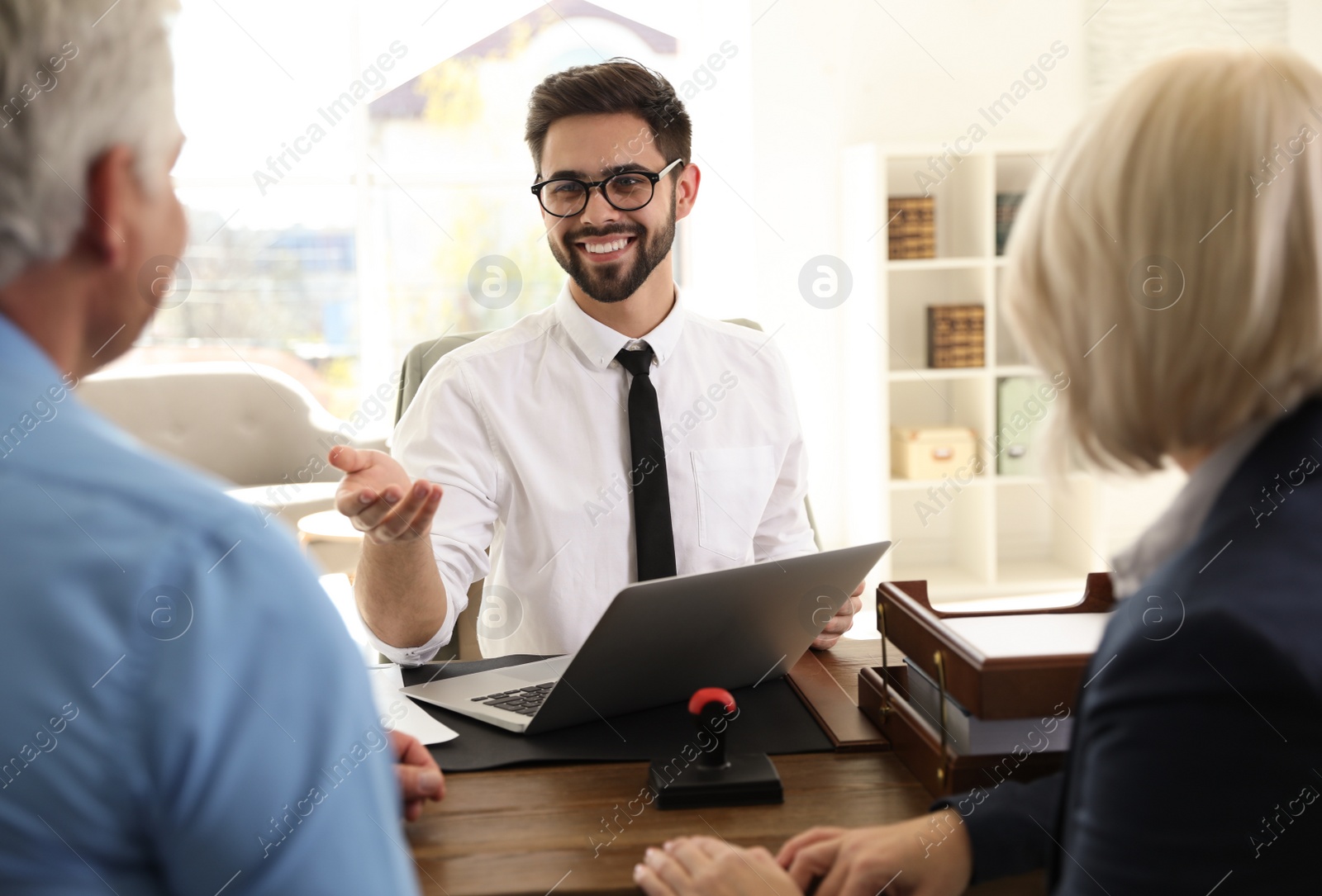 Photo of Male notary working with mature couple in office