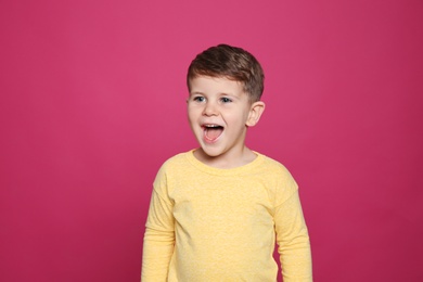 Photo of Portrait of little boy laughing on color background