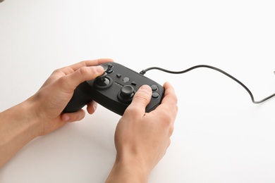 Photo of Young man holding video game controller on white background, closeup