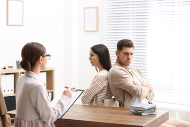 Photo of Professional psychologist working with couple in office