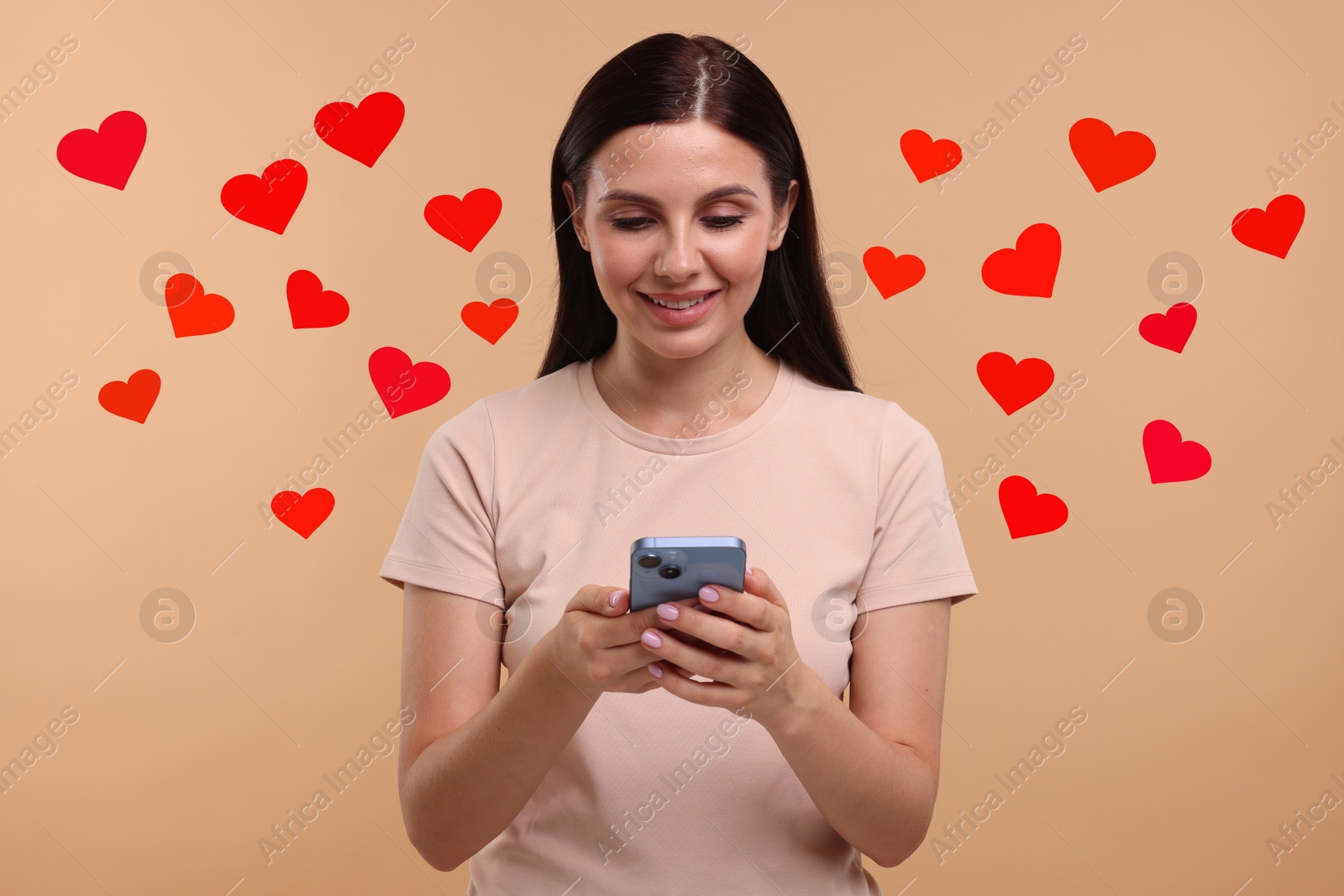 Image of Long distance love. Woman chatting with sweetheart via smartphone on dark beige background. Hearts flying out of device and swirling around her