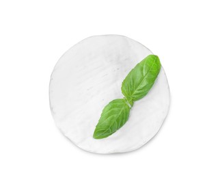 Photo of Tasty brie cheese with basil isolated on white, top view