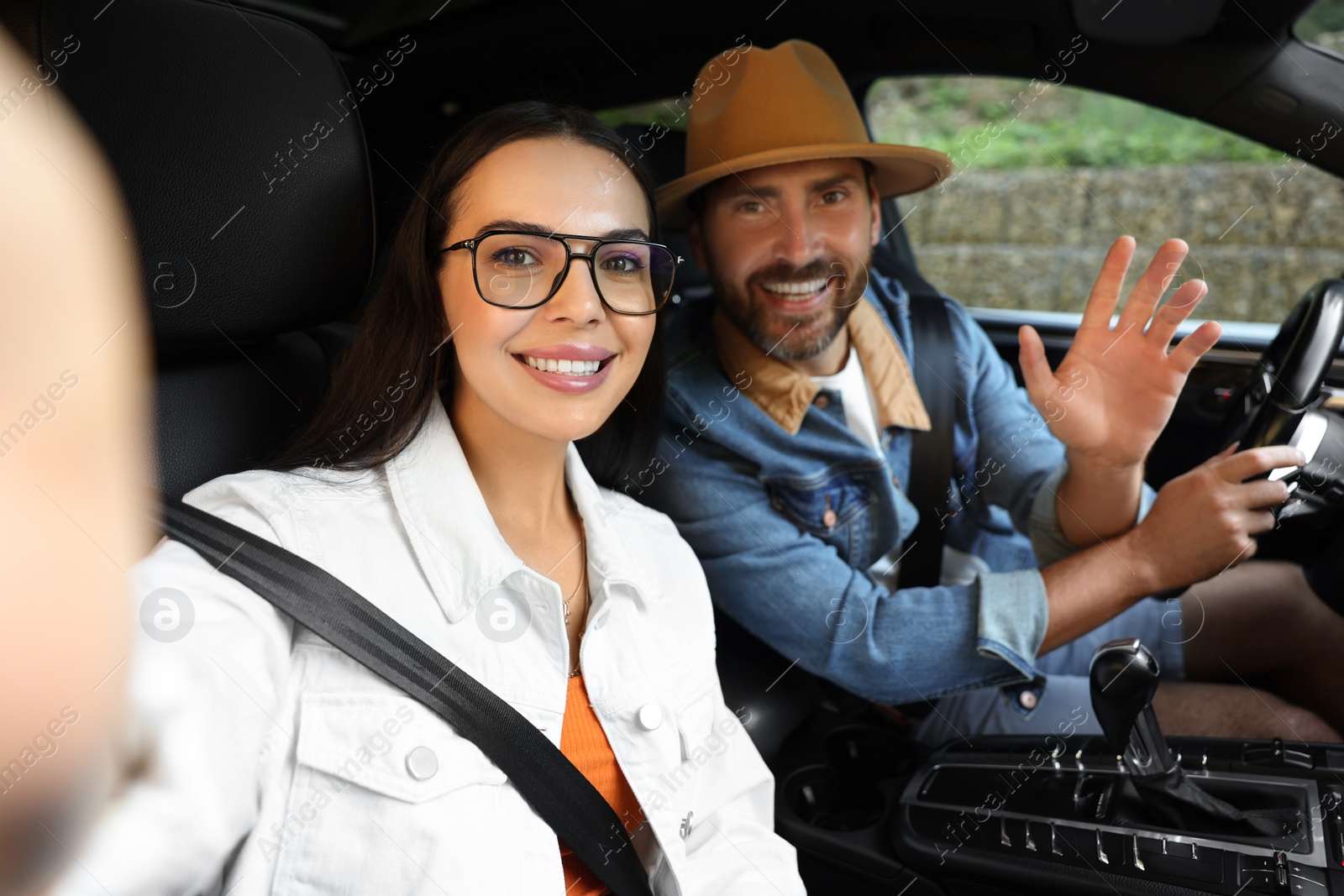 Photo of Happy couple taking selfie while enjoying trip together by car