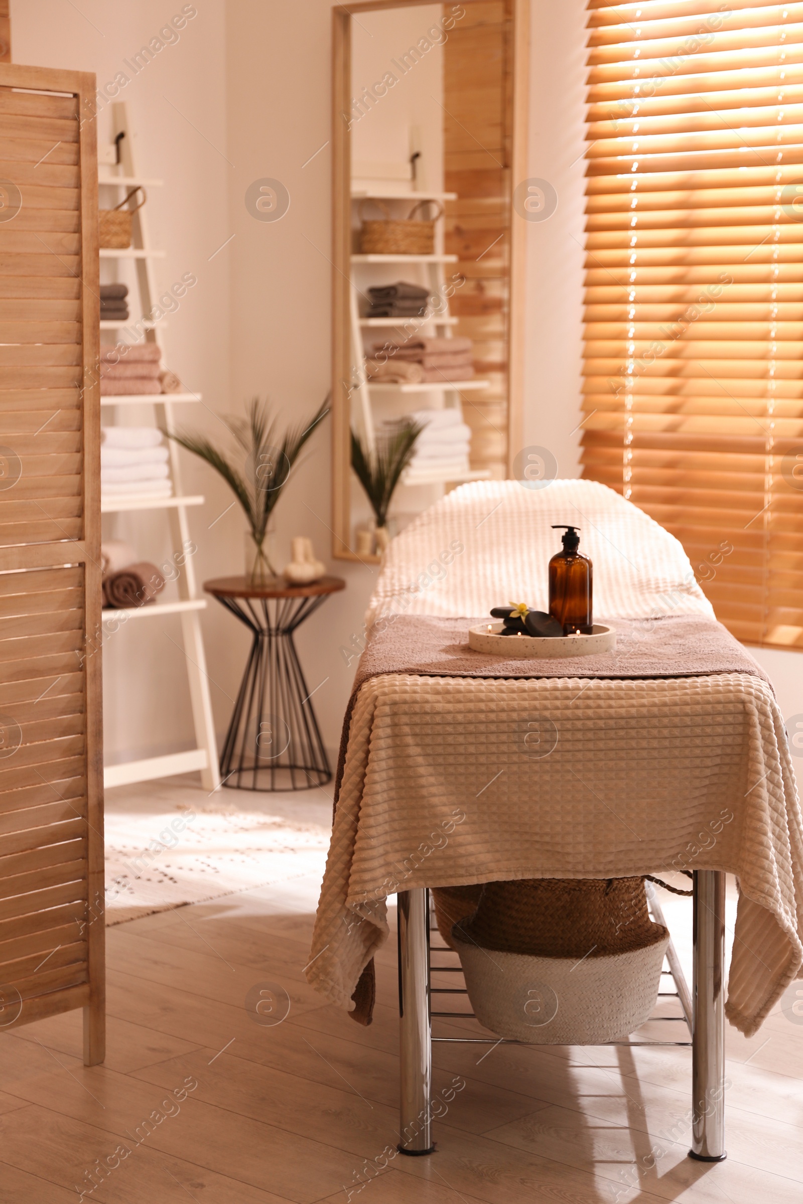 Photo of Beautiful spa accessories on massage table in room