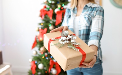 Young woman with Christmas gift at home