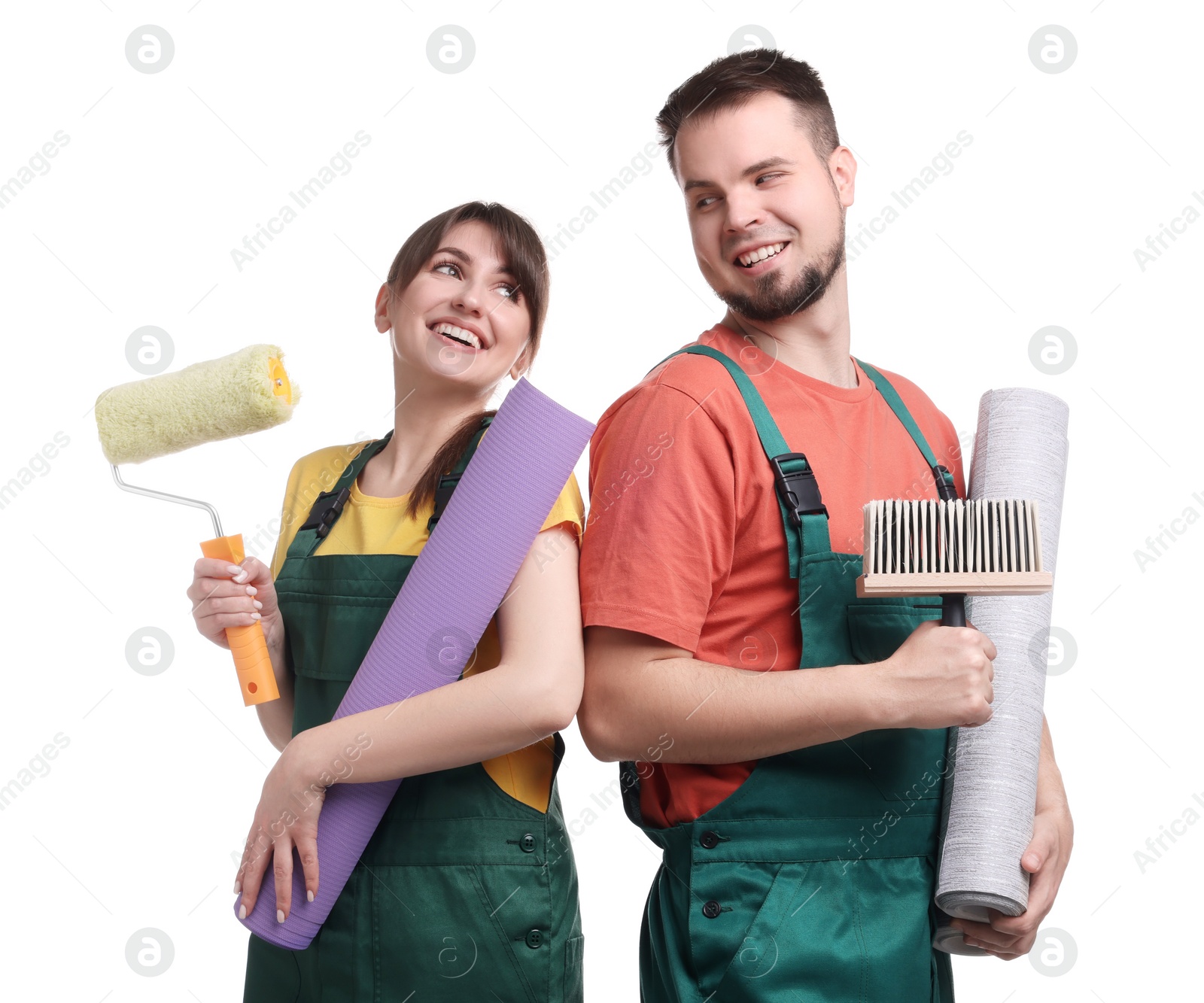 Photo of Workers with wallpaper rolls, roller and brush on white background