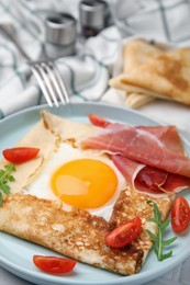 Photo of Delicious crepe with egg served on table, closeup. Breton galette