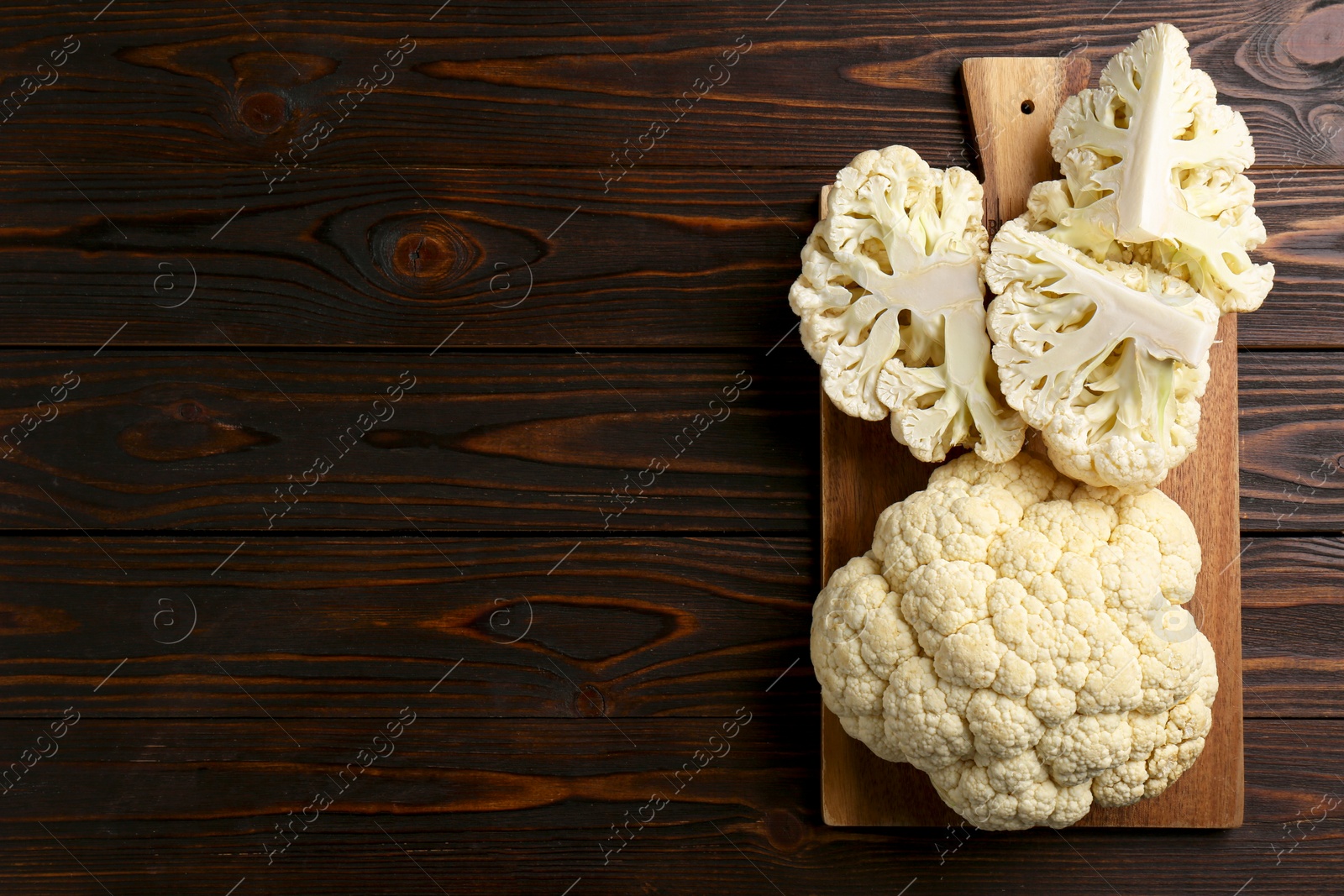 Photo of Fresh raw cauliflower on wooden table, top view. Space for text