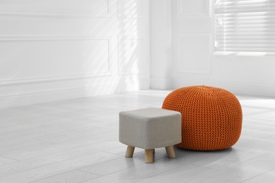 Stylish pouf and ottoman in room, space for text