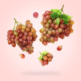 Image of Fresh grapes and leaves in air on light red background