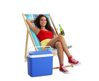 Photo of Happy young African American woman with bottle of beer resting in deck chair near cool box on white background