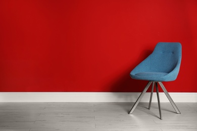 Photo of Blue modern chair for interior design on wooden floor at red wall