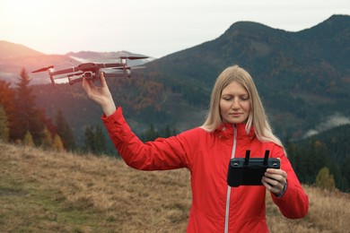 Young woman with modern drone in mountains