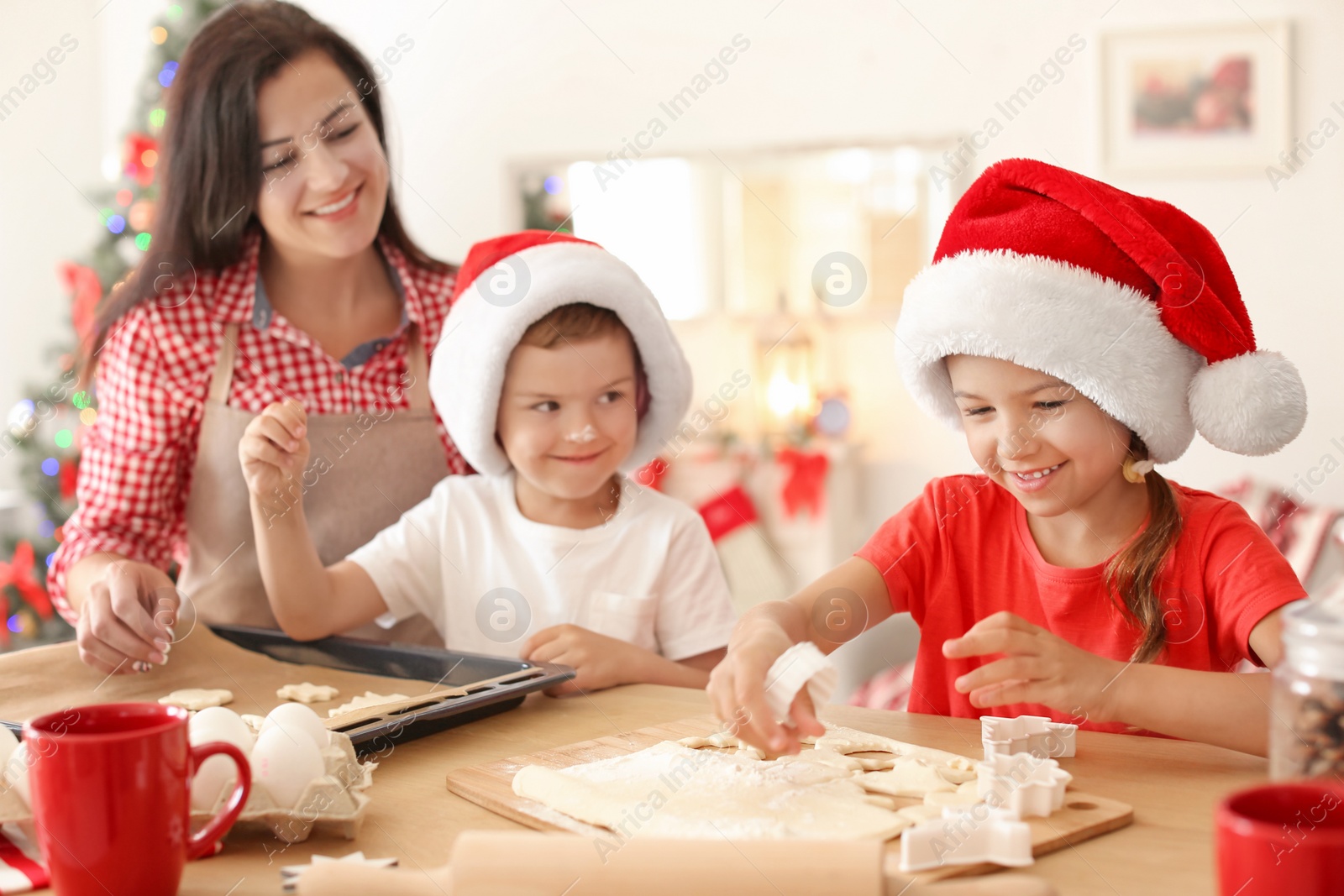 Photo of Mother and children making Christmas cookies together at home