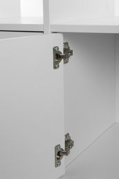 Photo of Empty white cabinet with open door, closeup. Furniture for wardrobe room