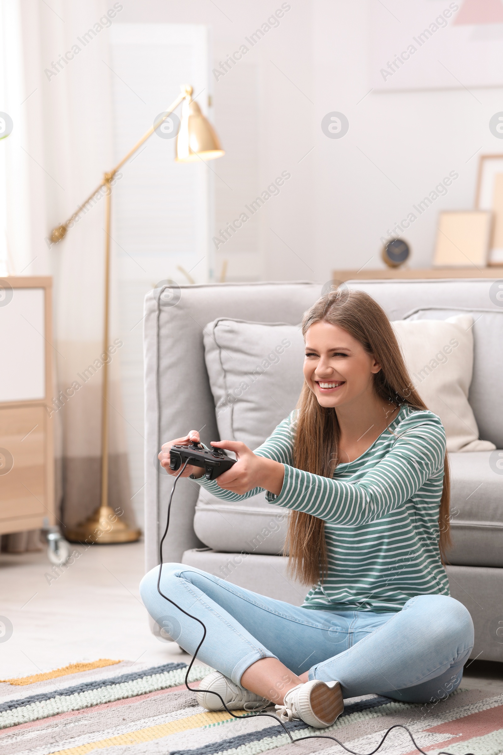 Photo of Emotional young woman playing video games at home