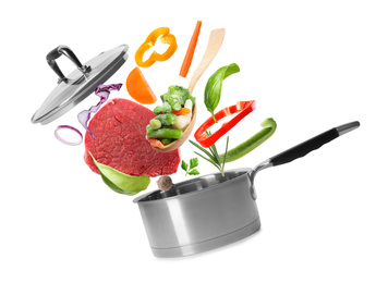 Pot and fresh ingredients for soup on white background