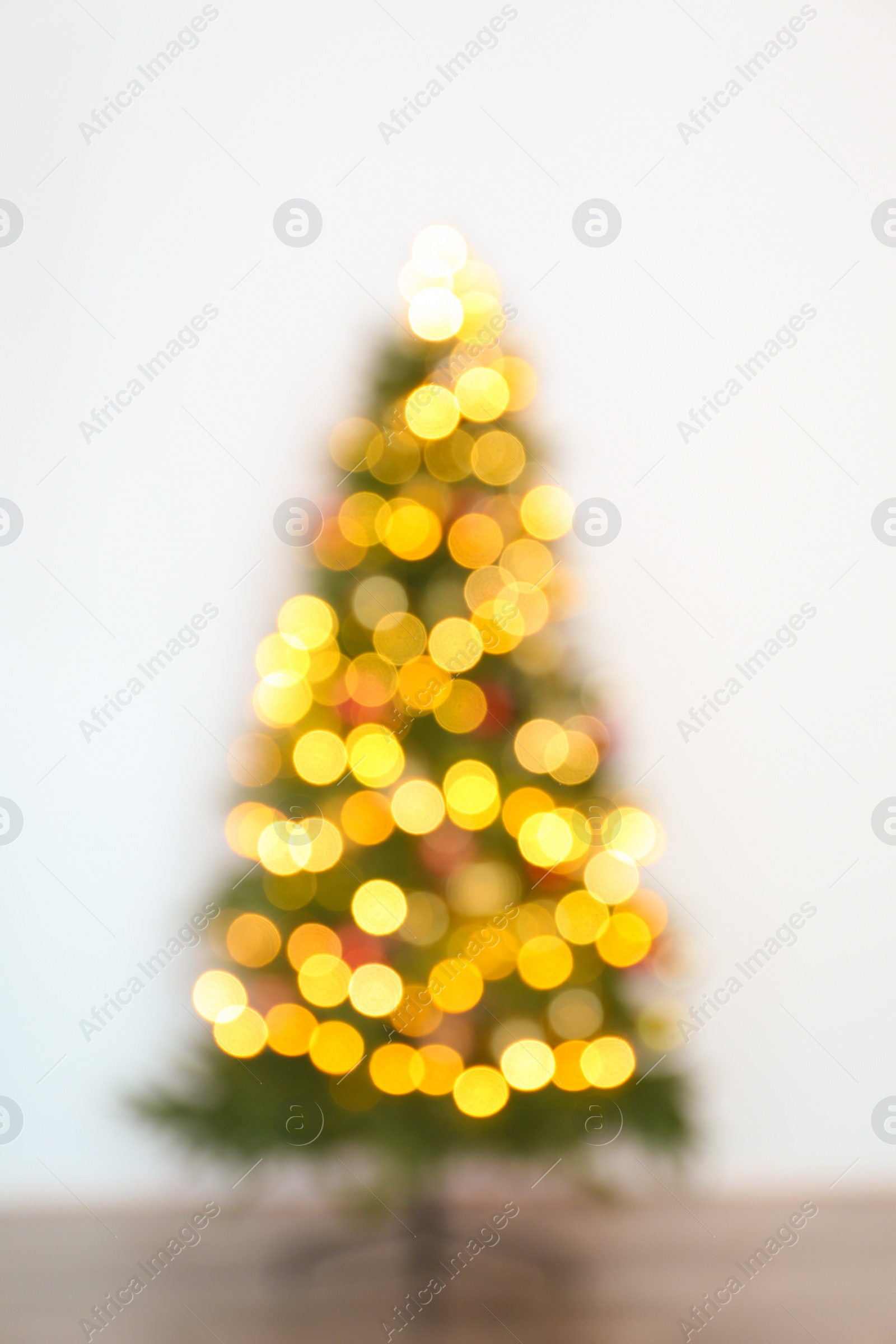 Photo of Blurred view of beautiful Christmas tree with fairy lights, indoors