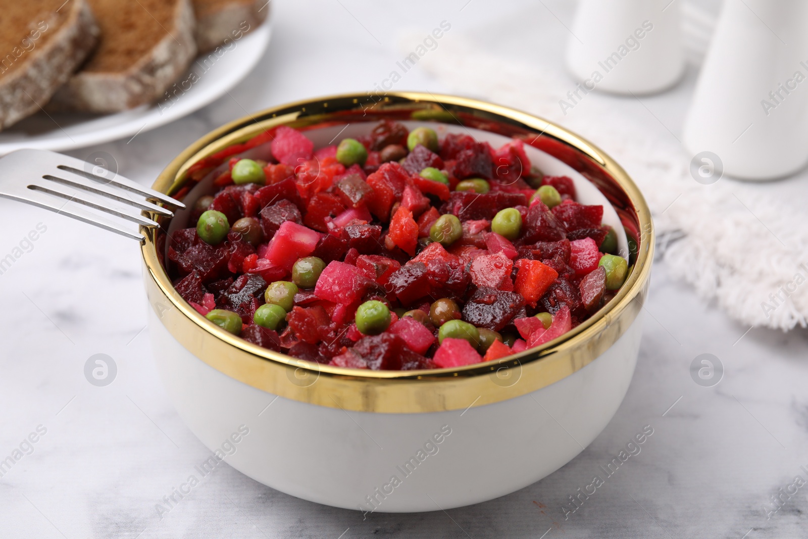 Photo of Delicious vinaigrette salad on white marble table, closeup