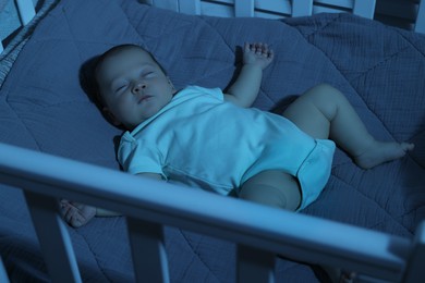 Photo of Cute newborn baby sleeping in crib at night