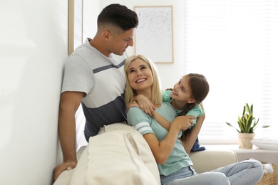 Happy family with daughter on sofa indoors