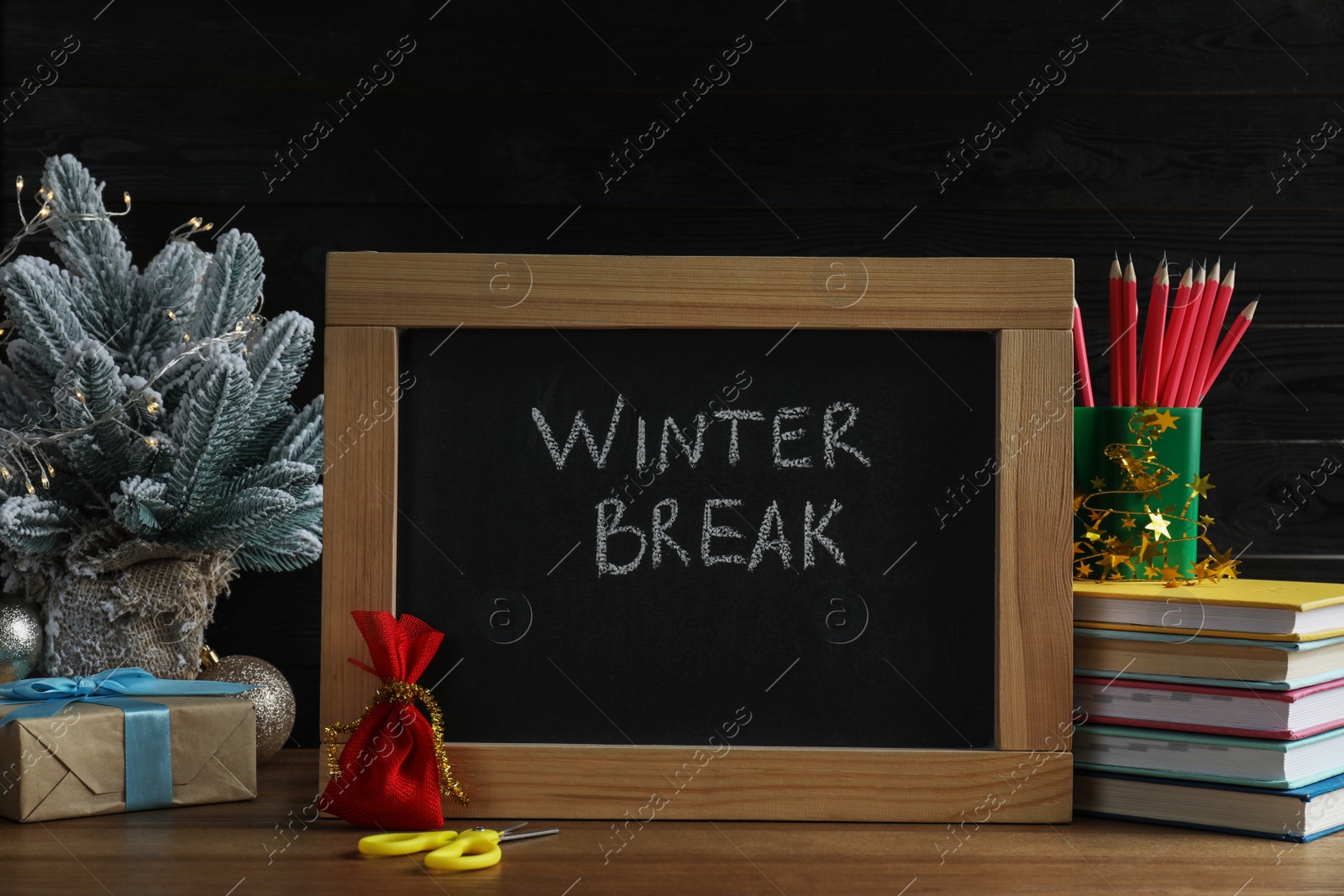 Photo of Chalkboard with phrase Winter Break, Christmas decor and stationery on wooden table. Holidays concept