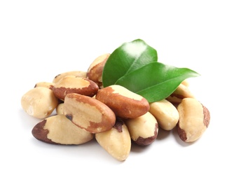Brazil nuts with green leaves on white background