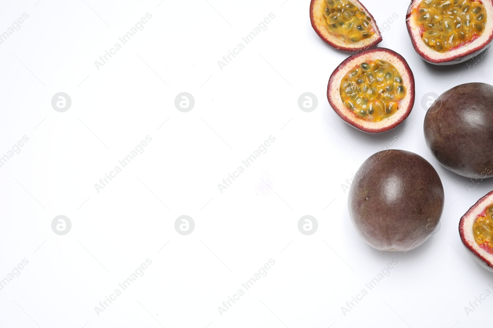 Photo of Fresh ripe passion fruits (maracuyas) on white background, flat lay. Space for text