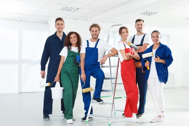 Photo of Team of professional painters with tools indoors