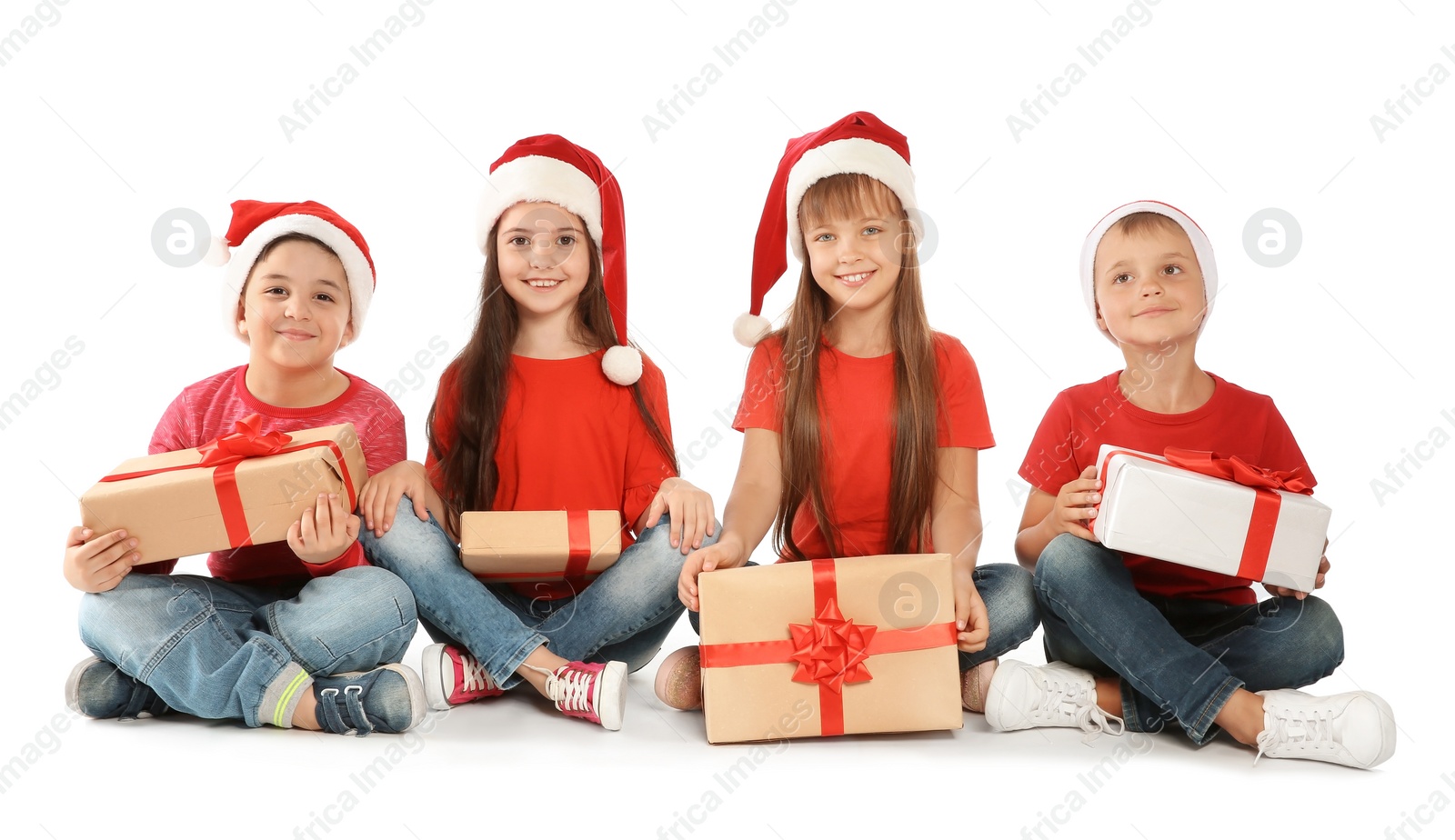 Photo of Cute little children in Santa hats with Christmas gifts on white background